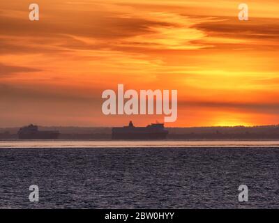 Sheerness, Kent, UK. 28th May, 2020. UK Weather: shipping on the Thames passes the sunset as seen from Sheerness in Kent. Credit: James Bell/Alamy Live News Stock Photo