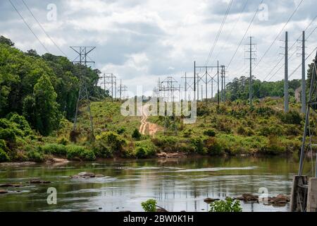 A group overhead high voltage power lines crossing a body of water Stock Photo