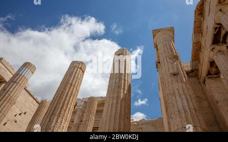 Athens Acropolis, Greece landmark. Ancient Greek pillars low angle view at Propylaea entrance gate, blue cloudy sky. Stock Photo