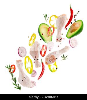 Flying chicken legs with vegetables and spices isolated on white background. Clean eating and bio concept Stock Photo