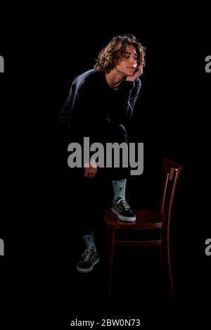Trendy modern young man dressed in trendy jumper and denim pants Stock Photo