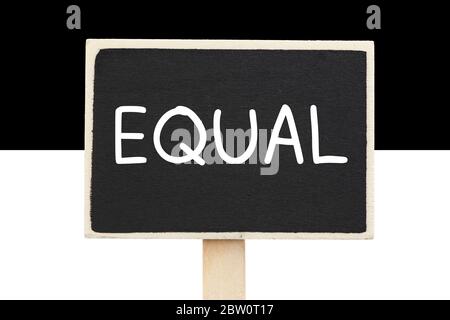 the word Equal written on a chalkboard against white and black background - Equality concept Stock Photo