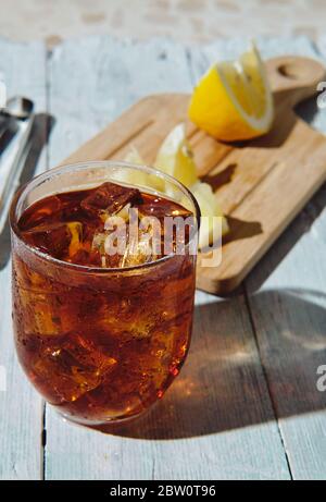 very cold cola on a white background with ice and lemon Stock Photo