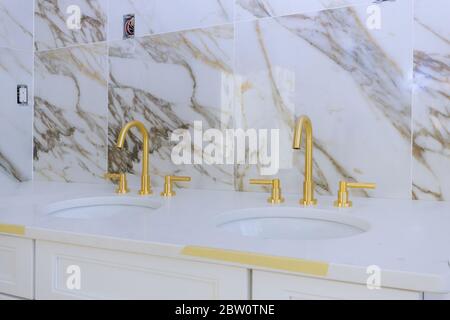 Expensive antique style gold plated handles with bathroom faucet in wash basin Stock Photo