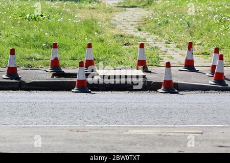 Traffic cones around work being carried out on a pavement Stock Photo