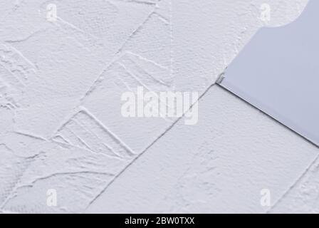 spreading white putty with plastic spatula, close up Stock Photo