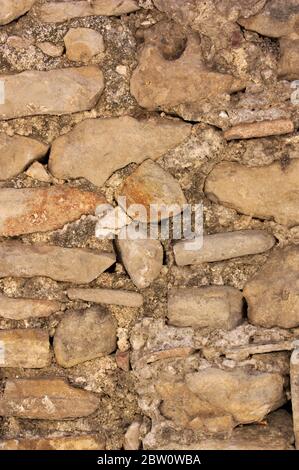 Close-up of an old wall made up of bricks and stones joined together in a rudimentary way without forming a concrete pattern Stock Photo