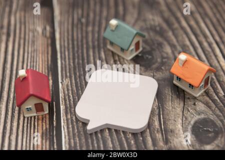 Several colored houses and paper stickers on a wooden background. Stock Photo