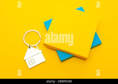 Colored stickers and a metal keychain in the form of a house on a yellow background Stock Photo
