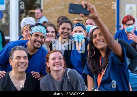 Staff at final clap for carers at 8pm Thursday outside Southend University Hospital, Essex, UK. Ward team gathering for a selfie. Doctors and nurses Stock Photo