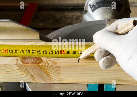 Closeup of professional cabinet makers working Measuring tape at woodworking workshop. Wood material production. Lumber factory. Stock Photo