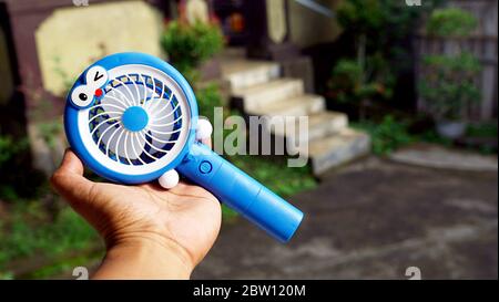 Close up hand holding a portable fan Stock Photo