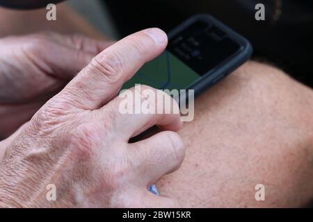 Hand of a senior Caucasian man using his phone to get directions. Stock Photo