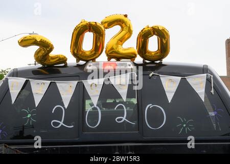 Class of 2020 balloons and writing on car windows during graduation parade through Austin neighborhood for seniors at Navarro Early College High School as they celebrate an academic finale shortened by the coronavirus pandemic. Stock Photo