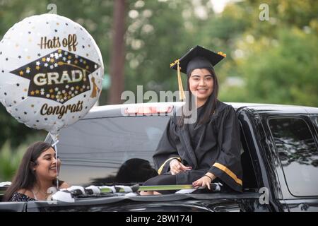 Austin, Texas, USA. 28th May, 2020. Texas graduates of Navarro Early College High School parade through their north Austin neighborhood on May 28, 2020 as they celebrate an academic finale shortened by the coronavirus pandemic. About 200 graduates piled into cars, waving at family and friends in the two-mile parade. Credit: Bob Daemmrich/ZUMA Wire/Alamy Live News Stock Photo