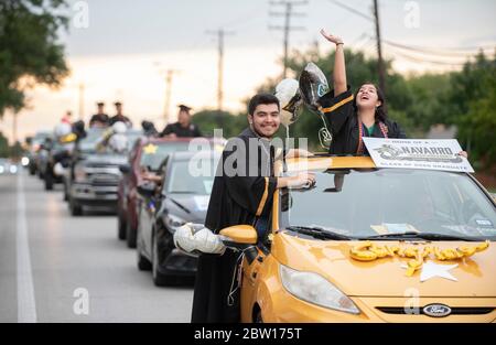 Austin, Texas, USA. 28th May, 2020. Texas graduates of Navarro Early College High School parade through their north Austin neighborhood on May 28, 2020 as they celebrate an academic finale shortened by the coronavirus pandemic. About 200 graduates piled into cars, waving at family and friends in the two-mile parade. Credit: Bob Daemmrich/ZUMA Wire/Alamy Live News Stock Photo