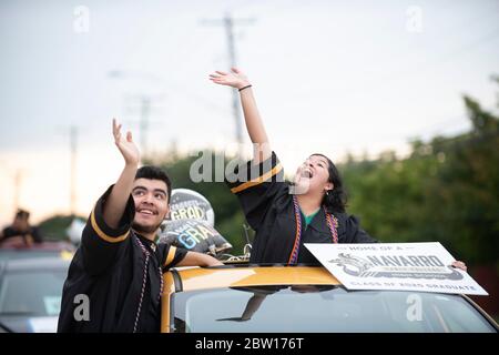 Austin, Texas, USA. 28th May, 2020. Texas graduates of Navarro Early College High School parade through their north Austin neighborhood on May 28, 2020 as they celebrate an academic finale shortened by the coronavirus pandemic. About 200 graduates piled into cars, waving at family and friends in the two-mile parade. Credit: Bob Daemmrich/ZUMA Wire/Alamy Live News Stock Photo