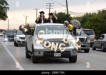 Austin, Texas, USA. 28th May, 2020. Texas graduates of Navarro Early College High School parade through their north Austin neighborhood on May 28, 2020 as they celebrate an academic finale shortened by the coronavirus pandemic. About 200 graduates piled into cars, waving at family and friends in the two-mile parade. Credit: Bob Daemmrich/ZUMA Wire/Alamy Live News Stock Photo