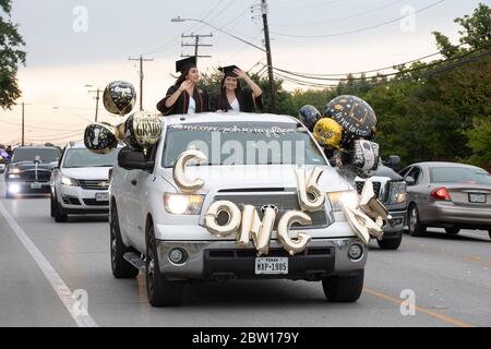 Austin, Texas, USA. 28th May, 2020. Texas graduates of Navarro Early College High School parade through their north Austin neighborhood on May 28, 2020 as they celebrate an academic finale shortened by the coronavirus pandemic. About 200 graduates piled into cars, waving at family and friends in the two-mile parade. Credit: Bob Daemmrich/ZUMA Wire/Alamy Live News Stock Photo