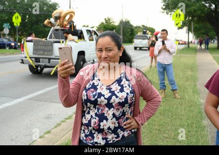 Austin, Texas, USA. 28th May, 2020. Texas graduates of Navarro Early College High School parade through their north Austin neighborhood on May 28, 2020 as they celebrate an academic finale shortened by the coronavirus pandemic. About 200 graduates piled into cars, waving at family and friends in the two-mile parade. Credit: Bob Daemmrich/ZUMA Wire/Alamy Live News Stock Photo