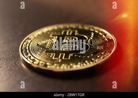 Bitcoin resting on a wood table, shallow focus and lens flare Stock Photo