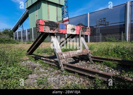 wooden buffer stop with red stop sign ending rail tracks concept for limit. Buffer stop . The final line Stock Photo