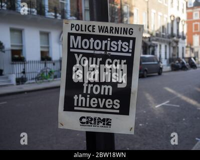 Police warning sign on a post that is warning motorists about car crime. London Stock Photo