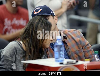 22 March 2014  Mila Kunis flaunts her engagement ring as she watches Detroit Pistons v Los Angeles Clippers with fiance Ashton Kutcher at the Staples Center, Los Angeles, CA June 2014 Stock Photo