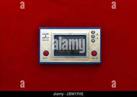 Photo of a vintage game console on a red table. Stock Photo