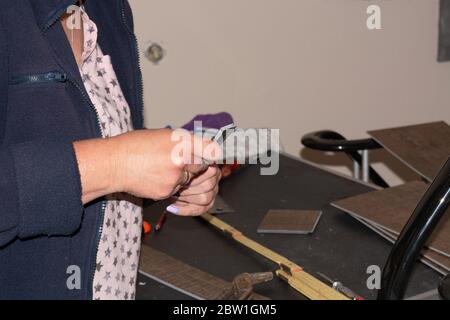 Woman in laying a laminate floor - closeup on female hands. Stock Photo