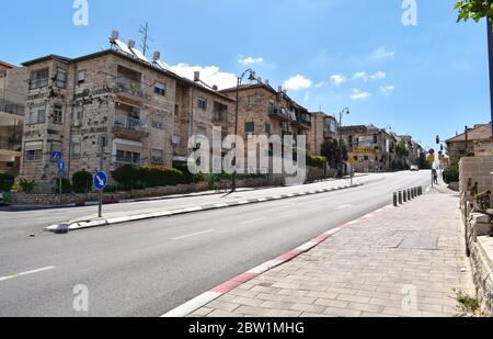 nearly empty street in Nakhalat Tsiyon in jerusalem israel during the corona virus covid pandemic lockdown with a clear sky and a few clouds in the ba Stock Photo