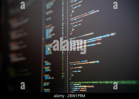 Javascript code in various colors on a dark mode computer screen. Stock Photo