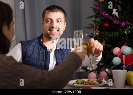 Family couple having christmas dinner with champagne and watching tv Stock Photo