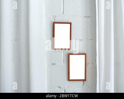White blank space on two wooden frames on white brick wall and white soft curtain background. Stock Photo