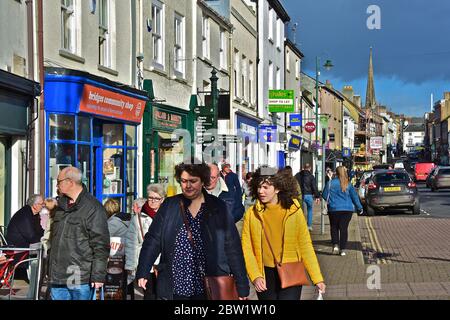 Saturday shoppers along Monnow Street, Monmouth, the busy main shopping street in this rural county town.Distant spire of St Mary's Priory Church. Stock Photo