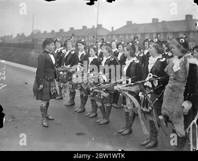 Dagenham Girl Pipers welcomed their new 'Chieftain'. Pipe Maj George Greenfield of the Royal Scots, recognised as one of Scotland's greatest experts on the bagpipes and Highland Dances, was met at Heathway station (District Railway) by the band of the Dagenham Girl Pipers in full uniform when he arrived at Dagenham, Essex, to become Pipe Maj of the Girl Pipers. George Greenfield enlisted in the Royal Scot as a boy piper and has now completed his 21 years service. As 'Chieftain' of the Dagenham Girl Pipers he will be responsible for the piping and dancing instruction of over 50 girls. Photo sho Stock Photo