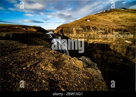 The magnificent waterfall Glymur in Iceland in the afternoon light on a sunny summer day, with gravel covered cliffs in the foreground Stock Photo