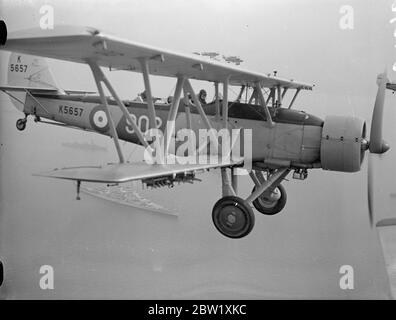 The King reviews fleet at Spithead. A Blackburn shark Mk II of 821 Naval Air Squadron a Royal Navy Fleet Air Arm are you from the aircraft carrier HMS courageous flies over the ships lined up for review in the Solent. 20 May 1937 Stock Photo