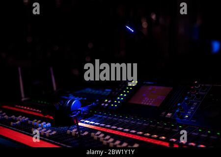 Headphones lying on a audio mixing console in a concert venue Stock Photo