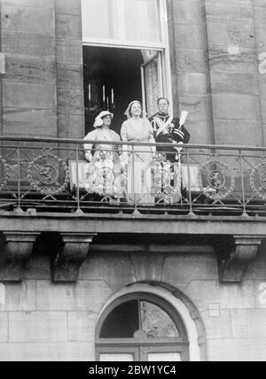 Princess Juliana and consort visit Amsterdam with Queen Wilhelmina. To be introduced to city officials. Driving in triumph through crowded and decorated streets, Princess Juliana and her consort, Prince Bernhard, arrived with her mother, Queen Wilhelmina on a visit to Amsterdam, chief city of Holland. The Royal family is paying a week's visit, so that the Queen can officially introduced the newly married couple to leading personalities of the city. Photo shows, Princess Juliana and Prince Bernhard with Queen Wilhelmina on the balcony of the Royal Palace in Amsterdam. 8 June 1937 Stock Photo