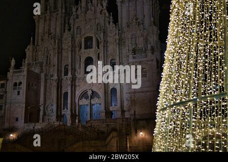 Close-up illuminated Christmas tree with warm LED lights. Santiago de Compostela, Plaza del Obradoiro. Cathedral in the background. Master Mateo. New