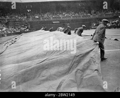 For the first time since the championships commenced, rain stopped play on the Central Court at Wimbledon, during the match between Fru Sperling, the Danish favourite for the women's title, and Miss Alice Marble, the American women's champion. Covering the Centre Court against the rain. 29 June 1937 Stock Photo