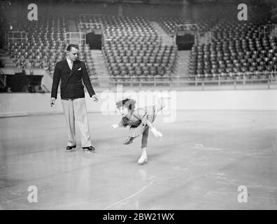 Five-year-old Beryl Bailey practices on the ice at Harringay Stadium, London under the critical eye of Albert Potts. Beryl gave an exhibition when the new season opened at the stadium, experts believe that in a few years she will be a champion. 19 September 1937. Stock Photo