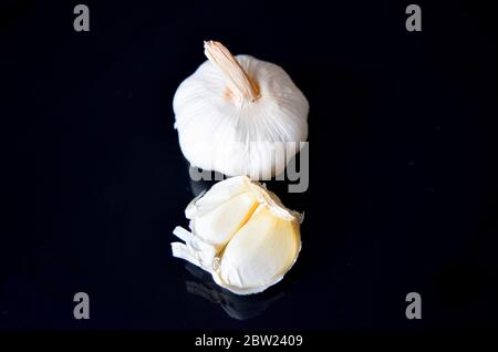 Whole garlic and cloves on dark black background. Stock Photo