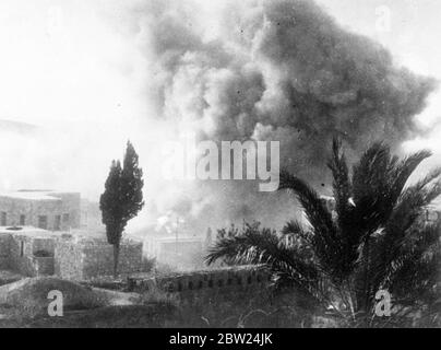 British troops, blow up 100 Arab houses in Palestine town. Royal Engineers dynamited over 100 Arab houses in Jenin, Palestine, following the murder by Arabs and Assistant District Commissioner Moffett of Jenin. The houses were destroyed, partly as a punitive measure against the inhabitants of the town having harboured Arab rebels and partly for reasons of security, houses in Jenin was built so close to one another that police and military patrolling was impossible. Photo shows, the pall of smoke and dust as the houses were blown up. 5 September 1938 Stock Photo