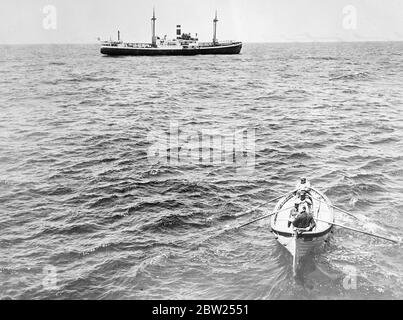 Doctors transferred by lifeboat to perform operation in Mid Ocean. Dr Frederik C Devendorf, ships surgeon and Dr P L Turner, who was making the crews as a passenger, were transferred by lifeboat from the ' Berinquen' of the Porto Rico Line to the SS Luna to perform an emergency operation in mid Ocean on Chief Officer Brooker of the Luna. 'Borinquen' had answered the distress signals. Photo shows, the doctors being transferred by lifeboat to the 'Luna'. 2 May 1938 Stock Photo