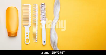 Shampoo, strand lock of blonde hair, different hair combs on color background. Dyed colored hair,hair care, hairdresser haircut beauty salon services Stock Photo