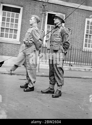 Army's experimental clothing on view in London. The experimental design of clothing for active service and training, which is to form the subject of trials by the army this year, was on view at the Central London Recruiting Depot, Great Scotland Yard, Whitehall. The equipment has been designed with a view to lightening as far as possible the weight carried by the soldier and taking into consideration mechanisation and the new weapons which have been adopted. Photo shows, soldiers wearing the basic equipment with small arm ammunition carriers (left) and the basic equipment with web pouches for Stock Photo