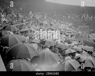 Rain stops play at start of Wimbledon women's semi-final. A sharp downpour stopped play when Miss Helen Jacobs met her countrywoman, Miss Alice marble in the semifinals of the women's singles of the Lawn Tennis Championships at Wimbledon, London. Photo shows, the sea of umbrellas on the Centre Court when rain stopped play at the start of the match. 30 June 1938 Stock Photo