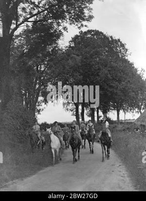Riders of the Garth Pony Club team, passing through a tree-lined country lane, on their way to Eastbourne from Winchester. Faced with 100 miles ride in four days, horsemen left Winchester today (Sunday) to attend the first National Horse Rally at Eastbourne, Sussex. Hundreds of riders are taking part in the Rally, which is organised on the lines of the motor concourse. 11 July 1937 Stock Photo